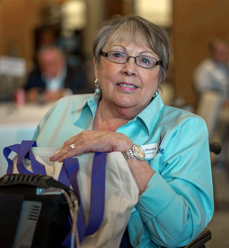 alpha-1 patient at a conference smiling at the camera
