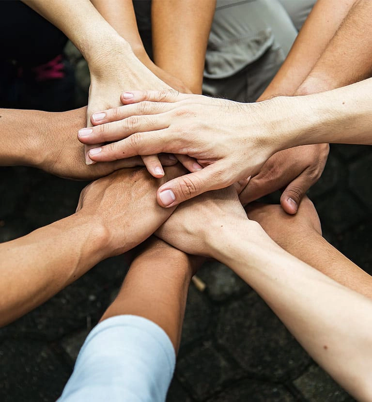 hands piling together to symbolize partnership